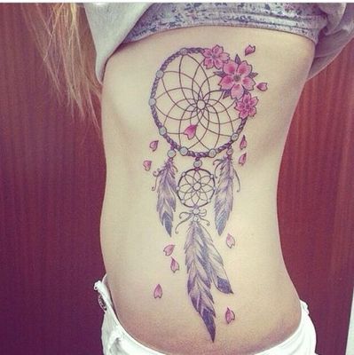  Tatouage attrape rêve avec des fleurs sur les côtes